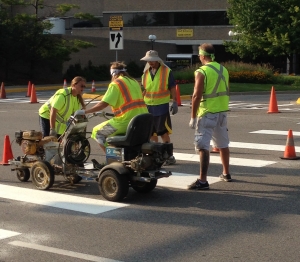 Road being striped for crosswalk by professional company